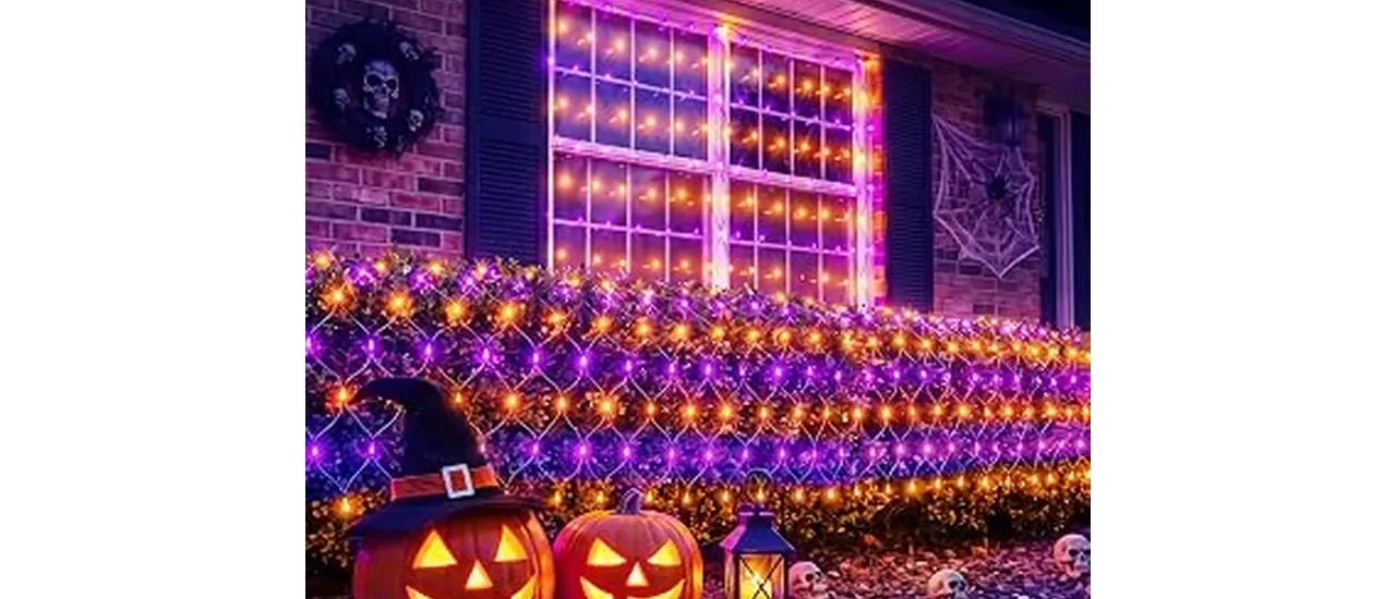 The image shows a spooky Halloween scene with glowing orange lights illuminating trees and bushes.