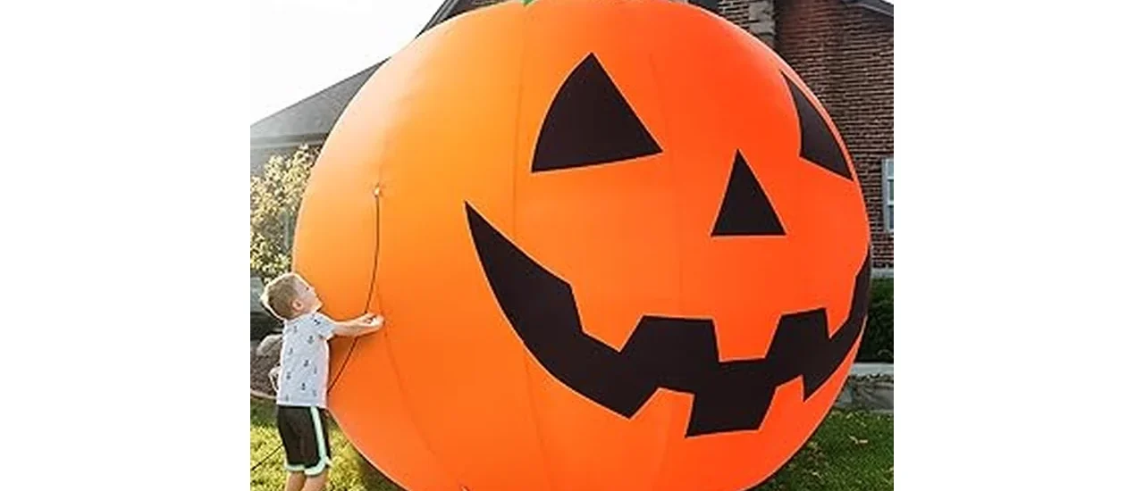 The image shows a large, glowing inflatable spider and ghost for a Halloween yard display.