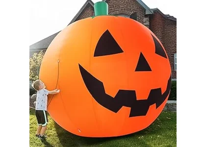 The image shows a large, glowing inflatable spider and ghost for a Halloween yard display.