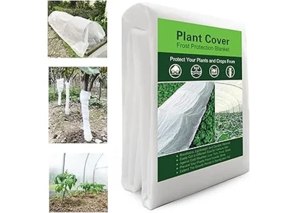 The image shows a garden bed covered with frost blankets protecting winter vegetables from cold.