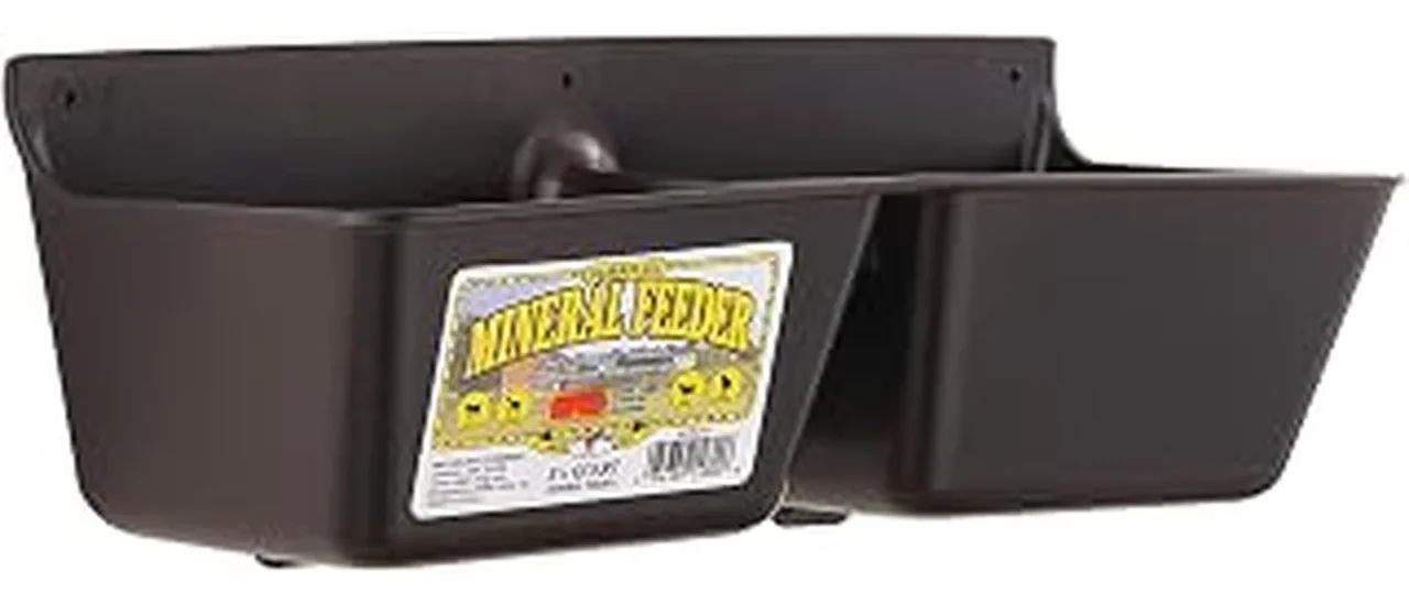 The image shows a robust cattle mineral feeder designed for winter conditions in a pasture setting.