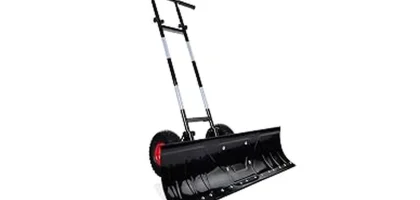 This image shows a powerful tractor clearing a large snowdrift with a heavy-duty snow pusher attachment.