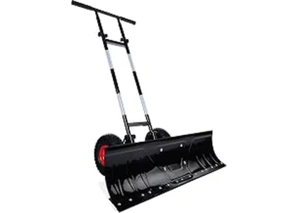 This image shows a powerful tractor clearing a large snowdrift with a heavy-duty snow pusher attachment.