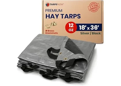 The image shows a stacked pile of hay covered securely with a heavy-duty tarp for protection.