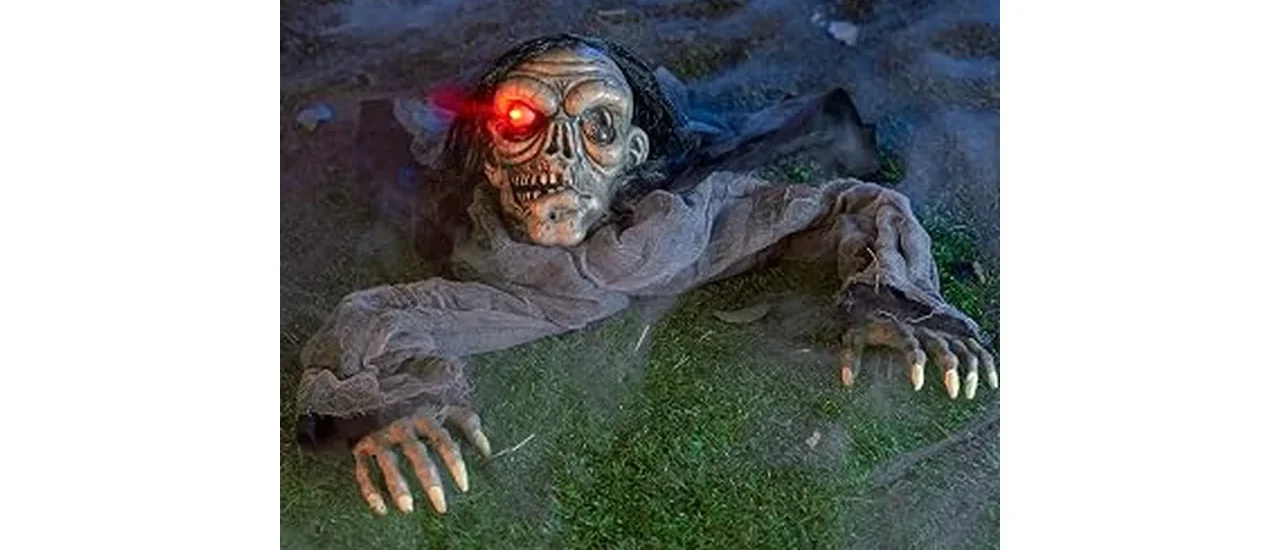 The image shows a festive outdoor Halloween display with pumpkins and spooky figures, part of a clearance sale.