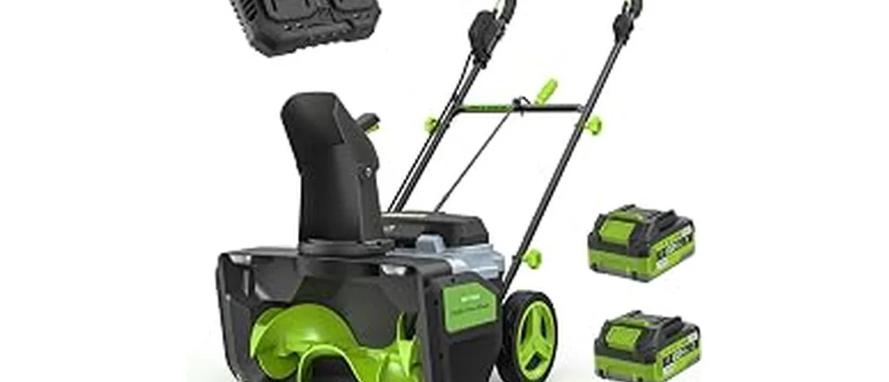 The image shows a powerful battery-powered snow blower clearing a large snowy driveway.