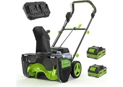 The image shows a powerful battery-powered snow blower clearing a large snowy driveway.